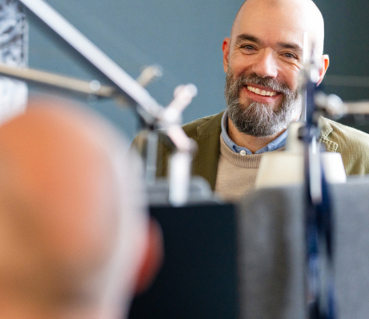 Man smiling at colleague in office space